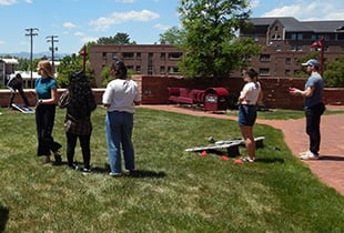 Students playing cornhole outside