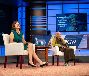 Seated speakers on stage at a conference