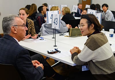 Groups of people talking at tables while seated