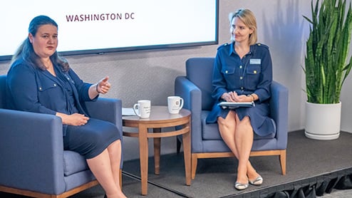 Two women seated on a conference stage