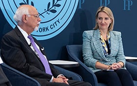 Two people seated on a conference stage