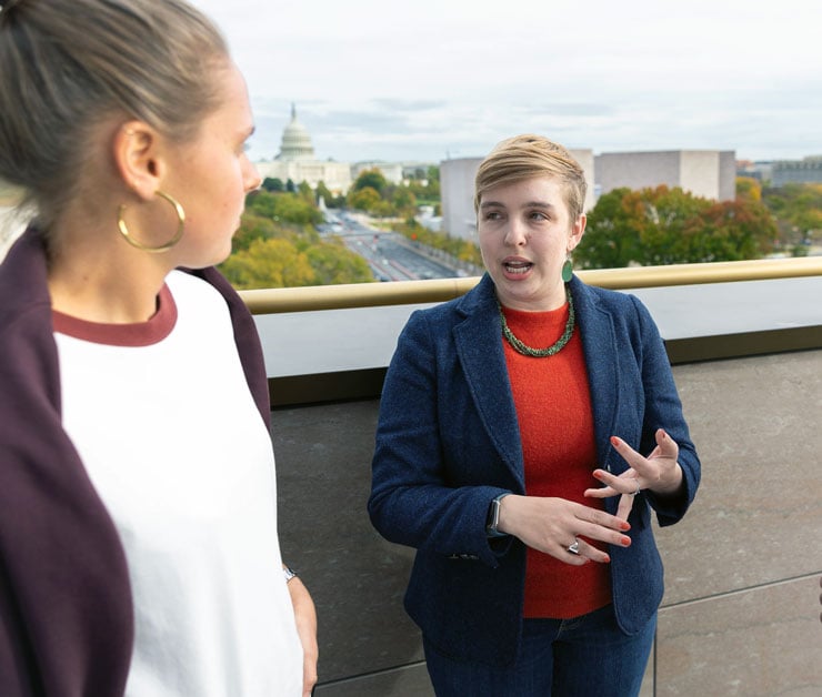 Two people talking outdoors with the Capitol building in the background