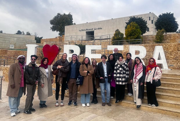 Students standing in front of an I heart Petra sign