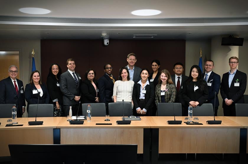 Students standing side by side smiling in a boardroom